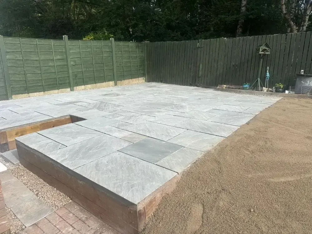 Raised sandstone patio on sleepers