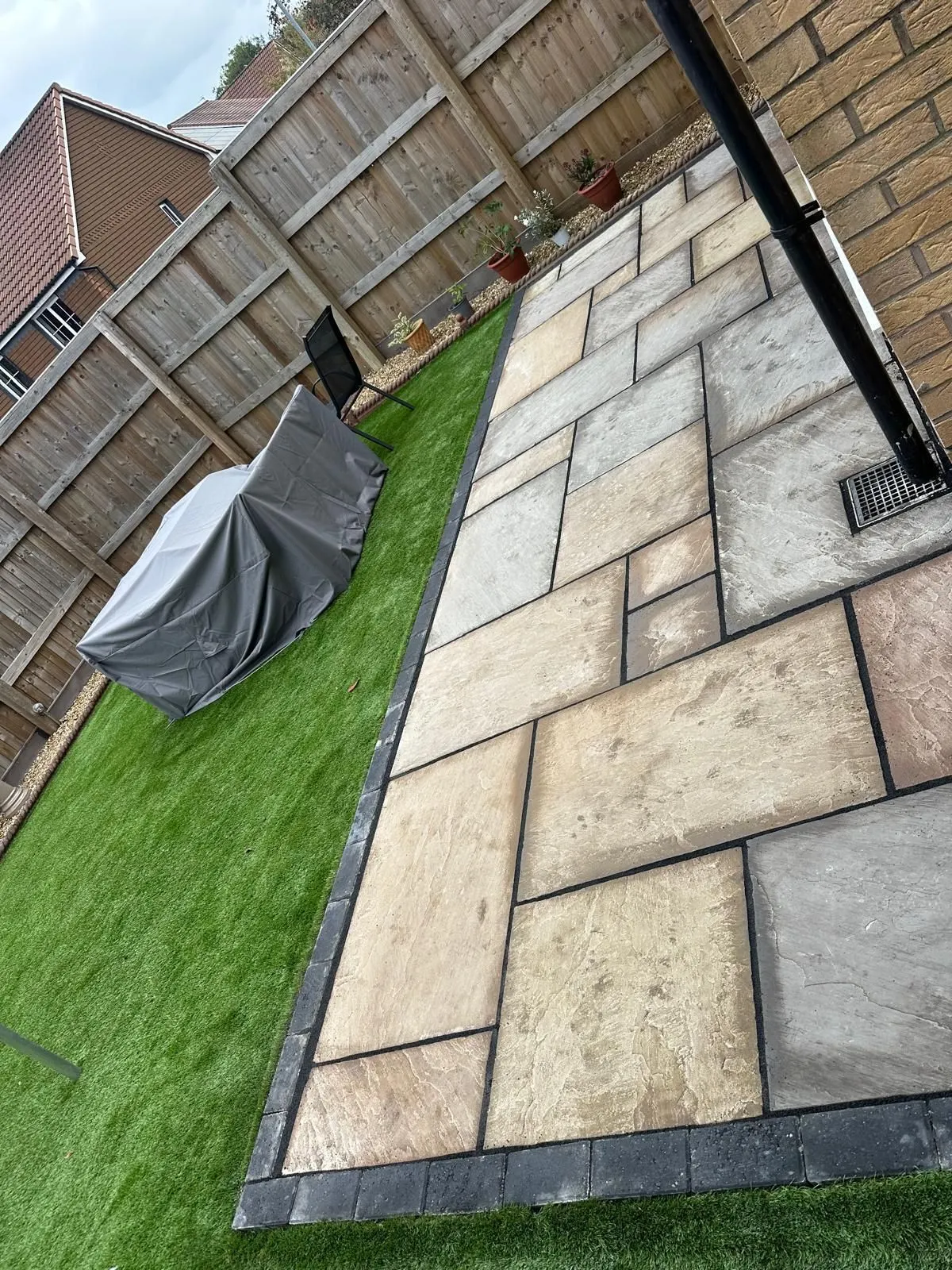 Sandstone patio strip beside artificial grass