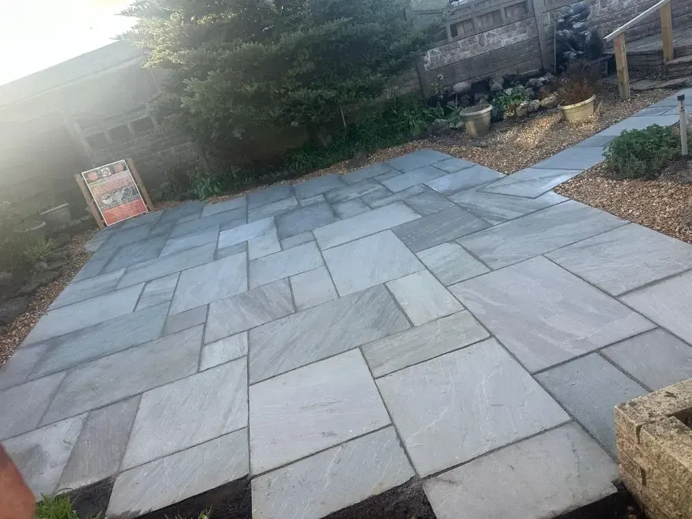 Grey riven sandstone patio with gravel