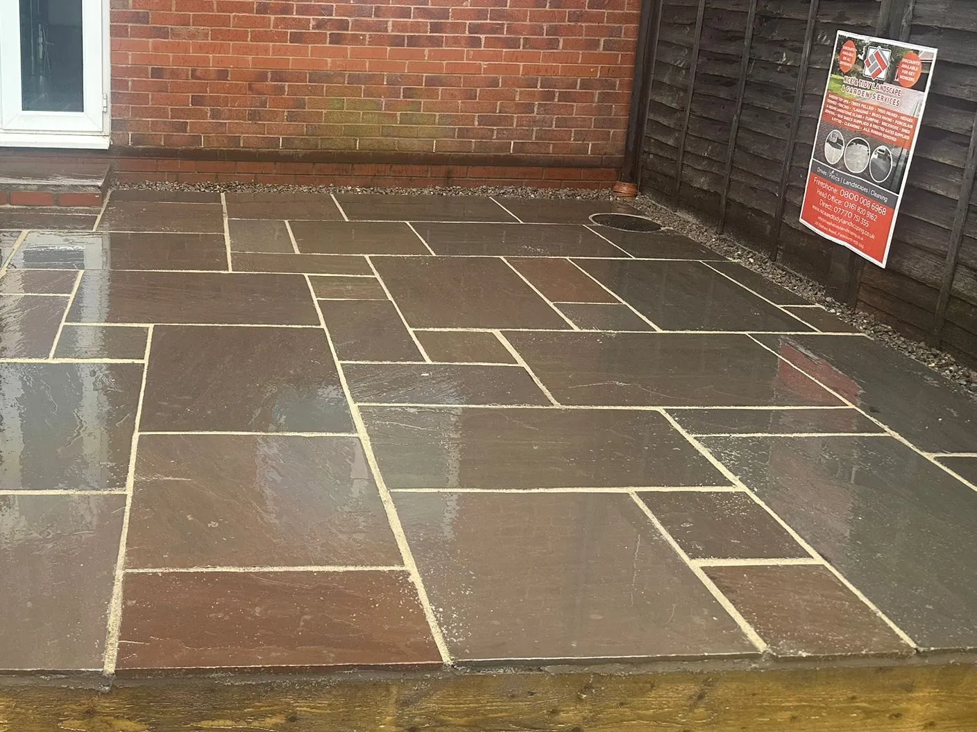 Raised multi colour sandstone patio on sleepers