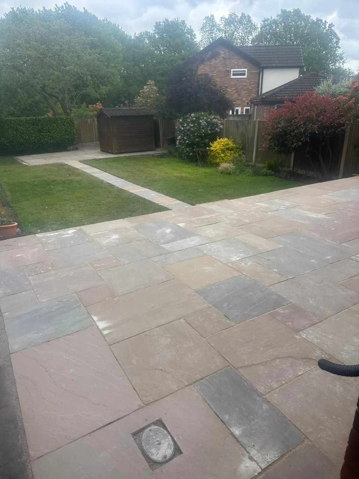 Sandstone patio with a path across the lawn