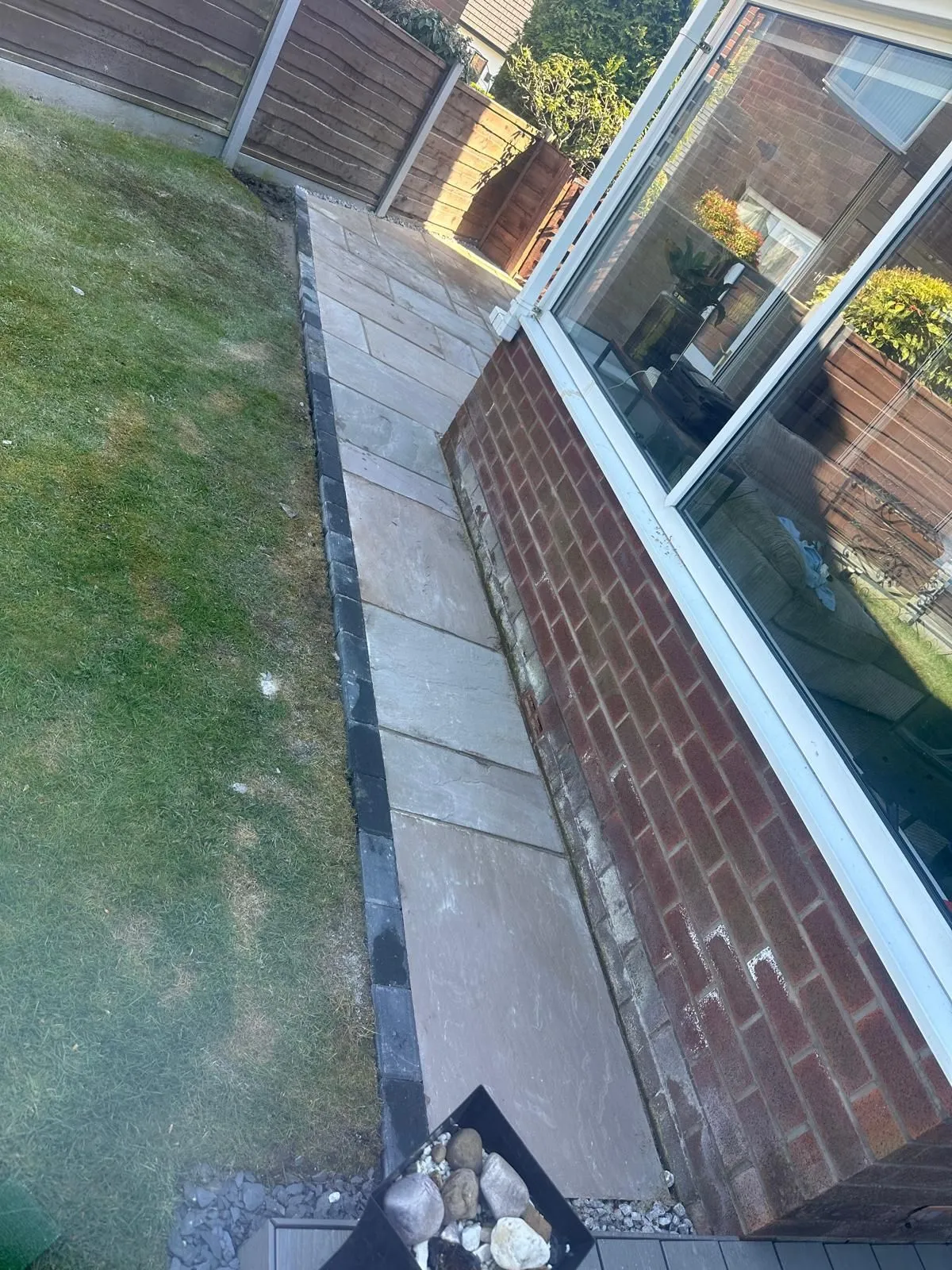 Sandstone path with a charcoal edge by a conservatory