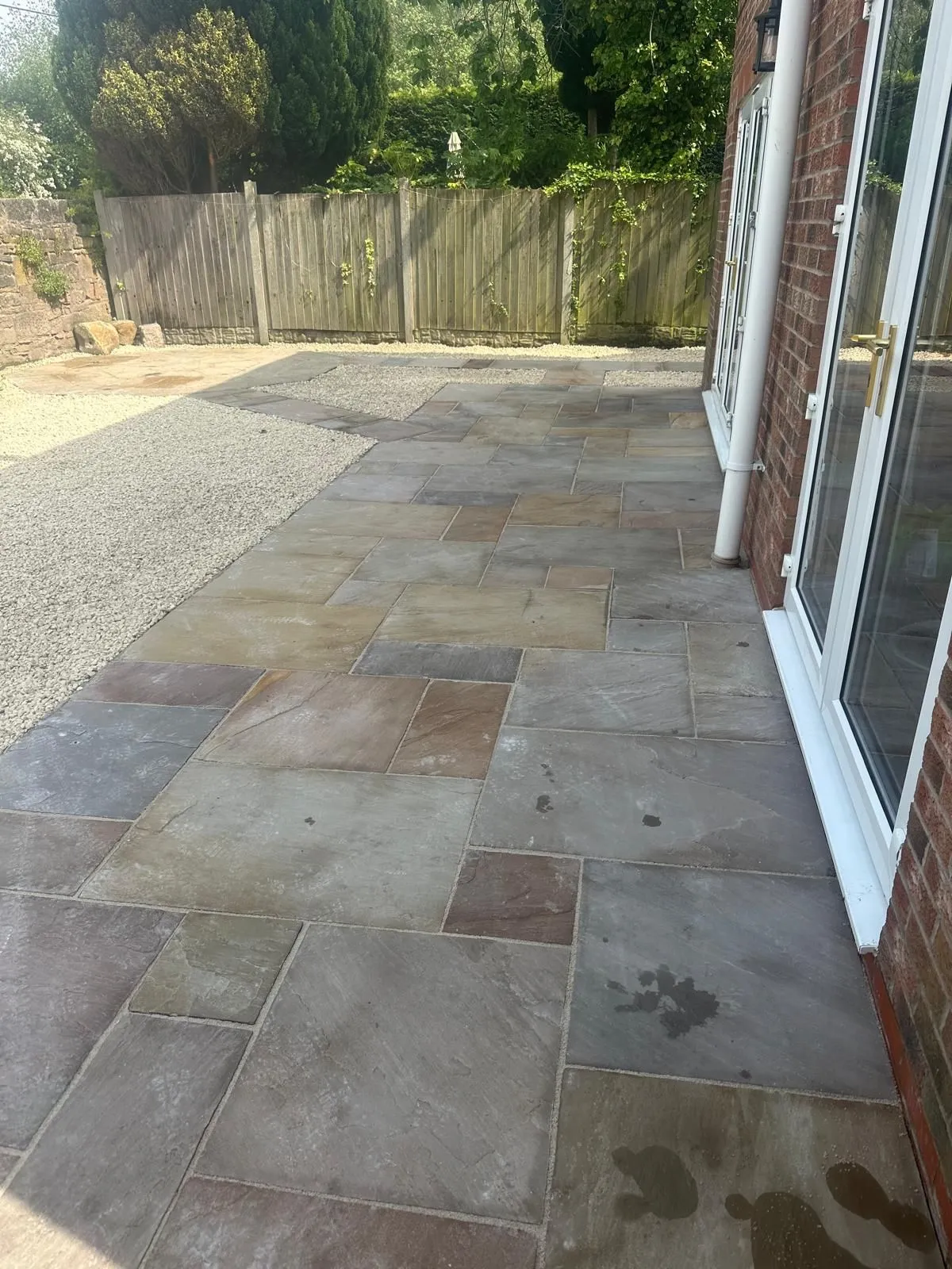 Sandstone patio by french doors with gravel