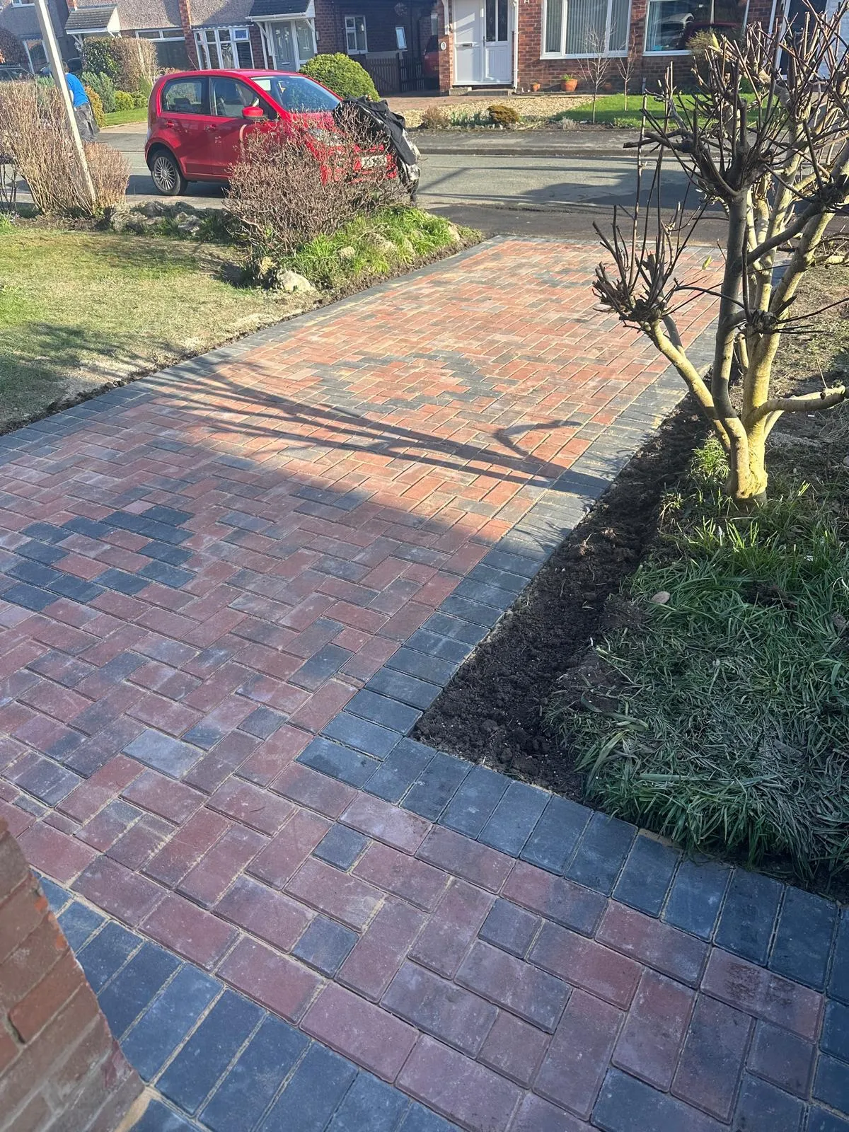 Block paved driveway with a charcoal pattern band