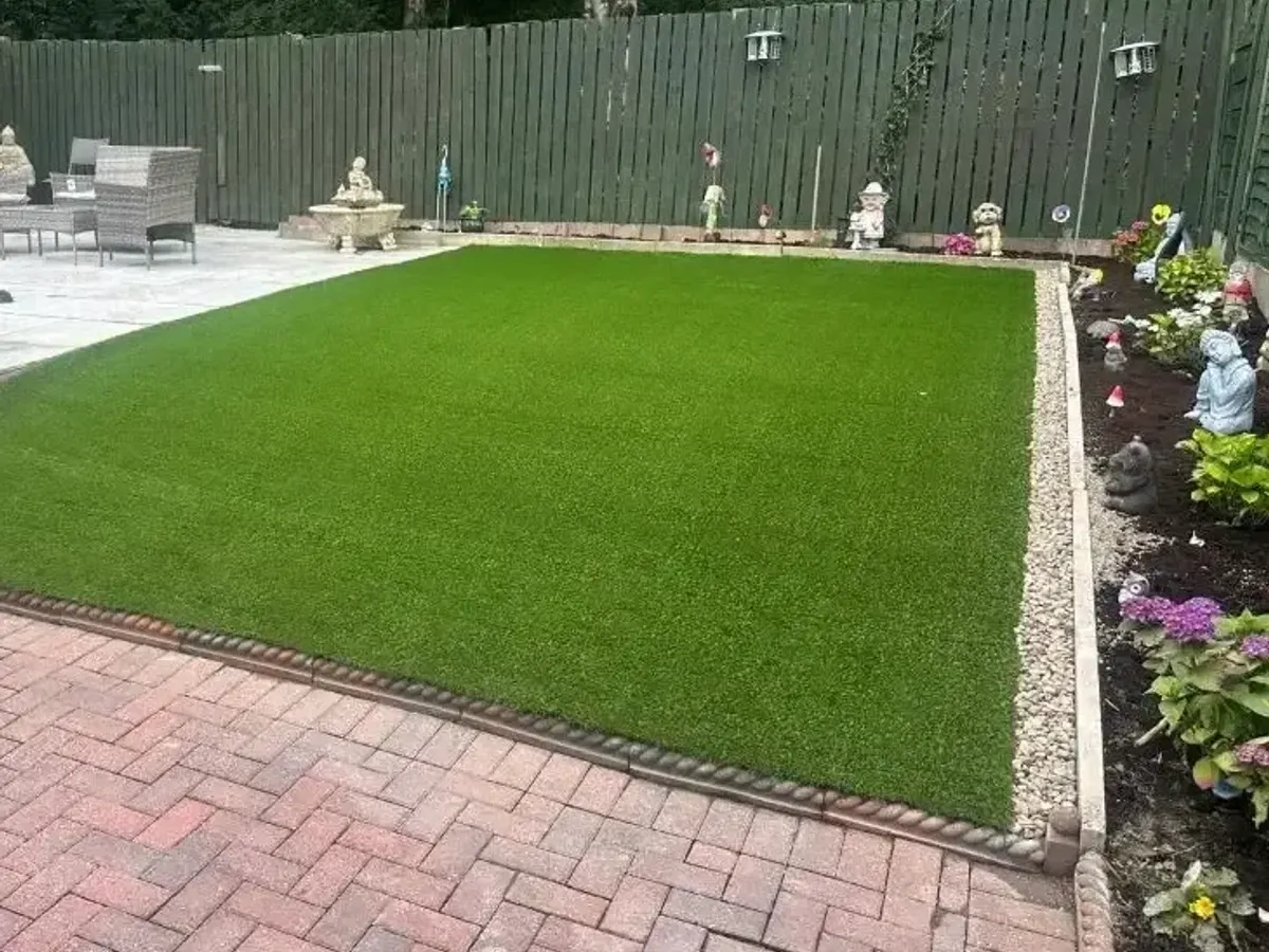 Finished garden with block paving, artificial grass and a sandstone patio in Manchester