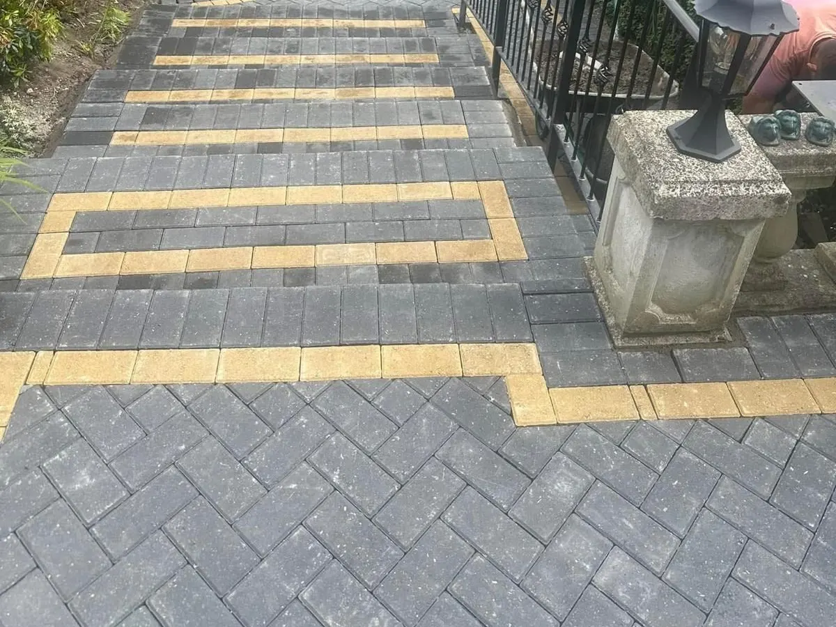 Block paved garden steps with buff pattern bands and a handrail in Greater Manchester