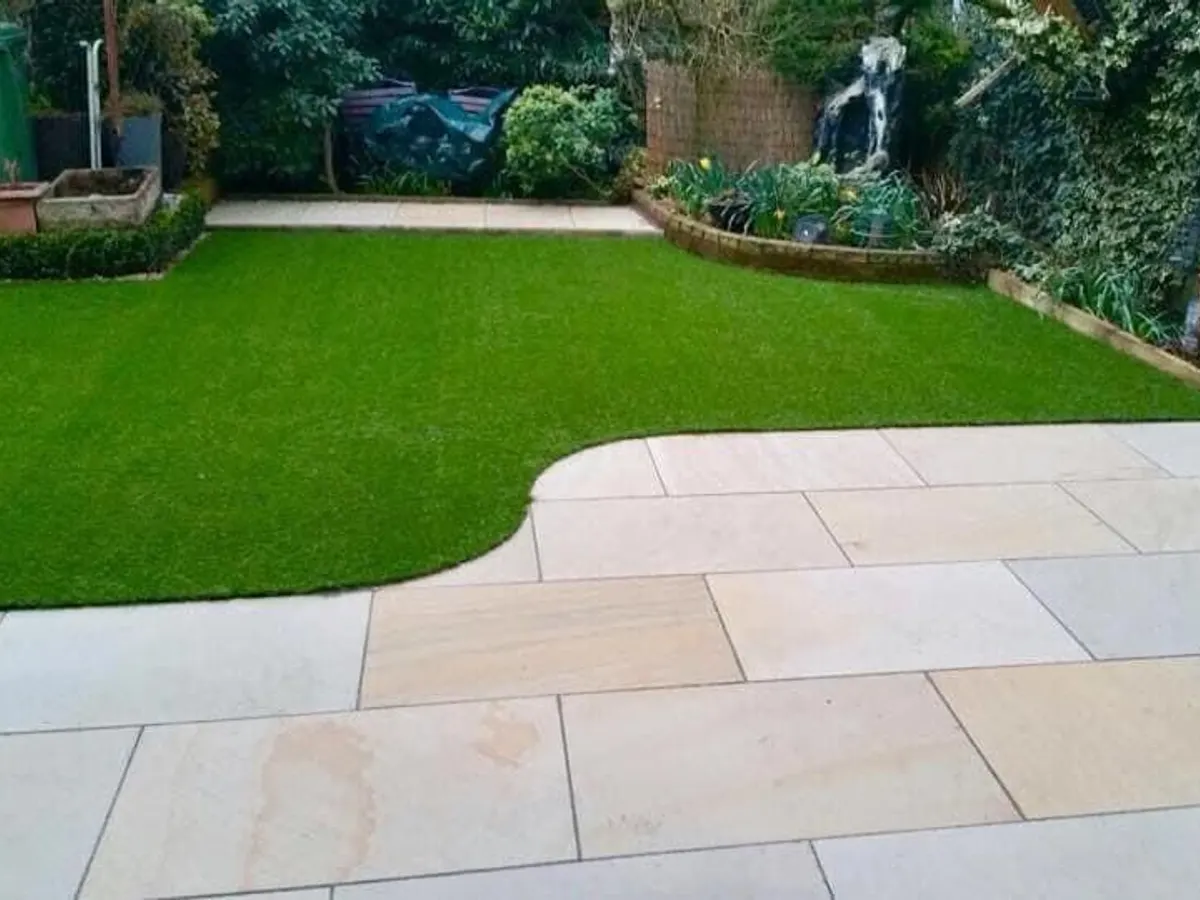 Sawn sandstone patio with a curved lawn edge in Manchester